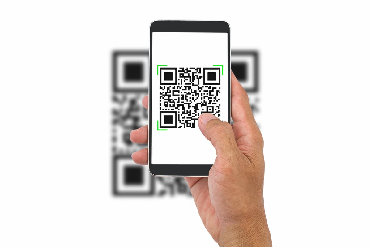 Hand holding smartphone scanning QR code, business concept